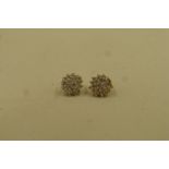 A pair of gold, diamond encrusted stud earrings stamped 10ct.