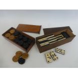 A cased set of dominoes and a cased set of turned wooden draughts pieces.