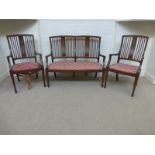 An Edwardian inlaid mahogany three piece parlour suite of two single chairs and a two seater