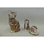 A Royal Crown Derby seated cat, a kitten and a piglet, all silver stoppers.