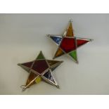 Two stained glass star shaped candle lanterns.