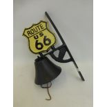 A cast metal wall mounted bell surmounted with a Route 66 U.S. shield.