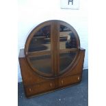 An oak Art Deco glazed two door cabinet, the upper section of circular form above a two drawer