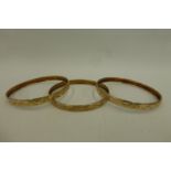 Three 9ct gold bangles with similar etched decoration, 18.2g.