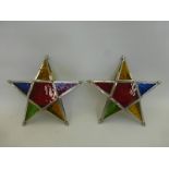 Two stained glass star shaped candle lanterns.