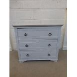 An Edwardian painted chest of three long drawers, raised on short shaped bracket supports.