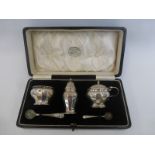 A cased silver three piece condiment set comprising of a salt, a pepper shaker and a lidded