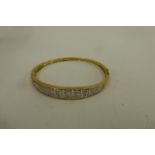 A gold bangle set with 0.25ct of diamonds, total weight 12.5g.