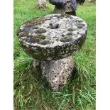 A staddle stone base with a milling stone forming the cap.