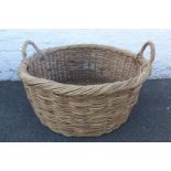 A large twin handled wicker log basket.