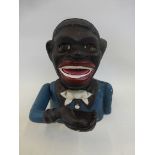 A cast metal novelty money box in the form of a native African man.
