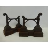 A pair of cast iron andirons in the manner of Christopher Dresser.