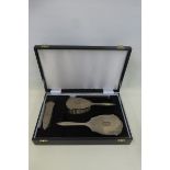 A four piece silver backed dressing table set in original case, all decorated with garlands of