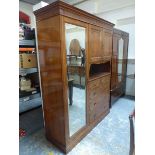 A Heals mahogany compactum with mirrored door enclosing hanging compartment flanking a cupboard,