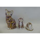 A Royal Crown Derby seated cat, silver stopper, a seated kitten, gold stopper and a piglet, silver