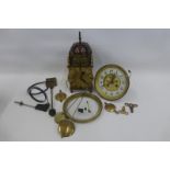 A box of assorted clock spares including a clock movement numbered 710 19455 and inscribed R. Parker