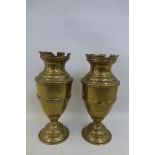 A pair of brass weighted castellated pedestal brass urns.
