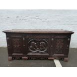 A Victorian oak coffer with carved panelled front and all-over carved decoration.