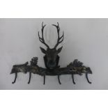 A wall mounted cup/key hook surmounted by a twelve pointed stag above an acorn branch with fruit and
