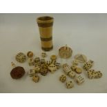 An assortment of ivory and bone dice, a shaker , a number spinning top etc.