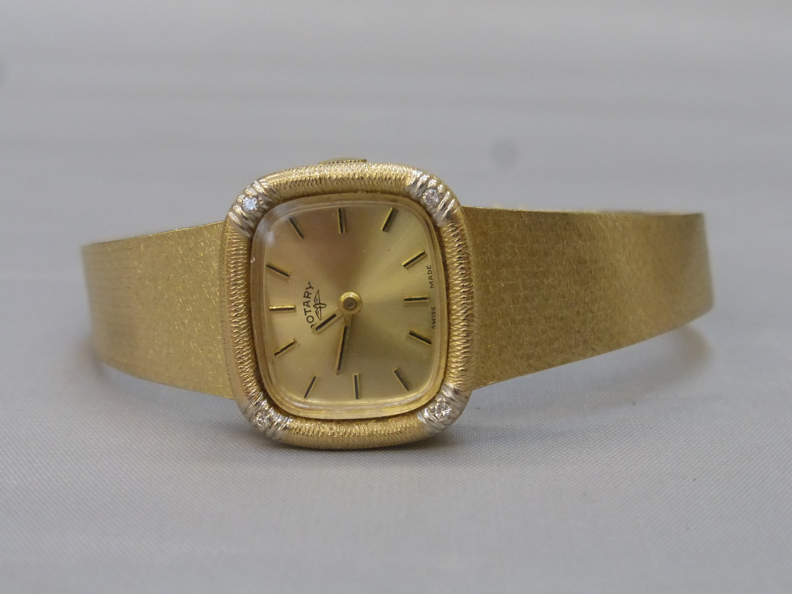 A 1960s 9ct gold lady's Rotary wistwatch set with four diamonds and a 9ct gold strap, weight 30.9g.