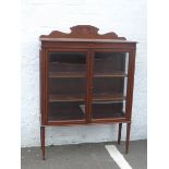 An Edwardian inlaid mahogany two door display cabinet raised upon square tapering supports.