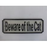 A cast metal wall mounted "Beware of the Cat" plaque.