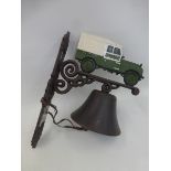 A wall mounted bell surmounted with a Land Rover.