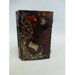 A tortoiseshell and silver inlaid calling card case/ book cover with two internal metal clips and an