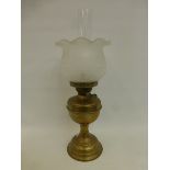 A brass oil lamp with frosted embossed tulip glass shade and clear glass funnel.