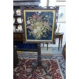 A fine Victorian glazed needlework pole screen, the tapestry enclosed within a carved pierced