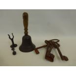 A set of four antique style jailer's keys and a wall mounted hand bell.