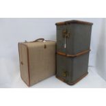 A canvas and wooden bound travel trunk and an Overpond plywood foundation case.