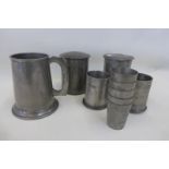 An Oriental pewter stacking cylindrical container with five internal pewter shot glasses stamped
