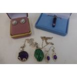 An assortment of silver pendant necklaces and earrings including a malachite pendant.