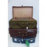 Three assorted suitcases, including a canvas covered suitcase, possibly military, and a Revelation.
