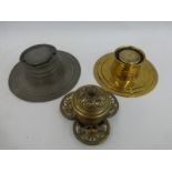 A pewter inkwell with glass liner, a circular brass inkwell with blue glass liner and a brass