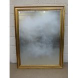 A large contemporary gilt framed rectangular shaped wall mirror.