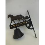 A wall mounted Welcome external bell surmounted with a mare and foal.