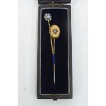 A gold (unmarked) and seed pearl cased tie pin and one other.