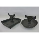 Two cast metal boot scapers with collecting trays.