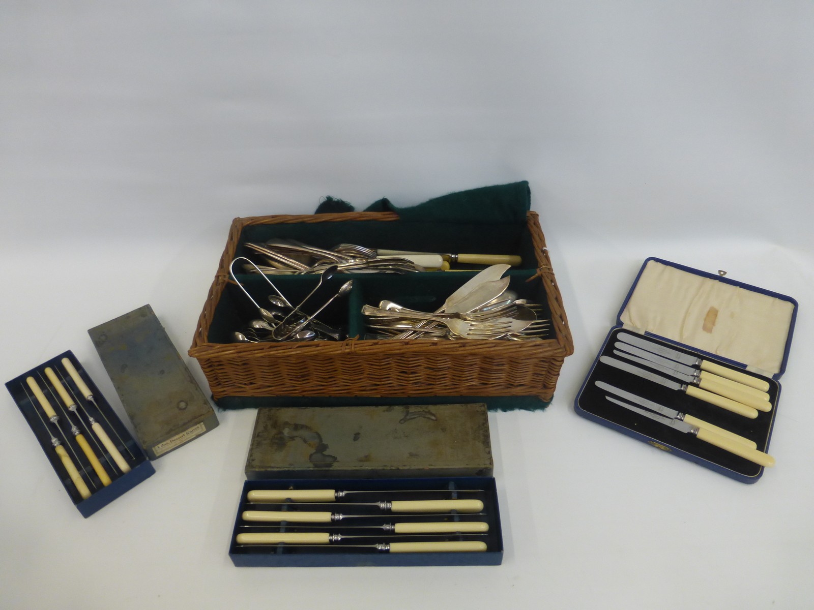 A basket of silver plated flatware, some boxed, knife rests, sugar nips etc.