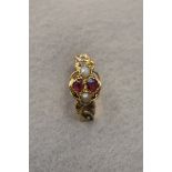 A 12ct rose gold ring with embossed decoration set with two rubies and two seed pearls, size P.
