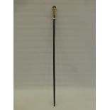 An ebonised walking cane with upper horn handle and precious yellow metal knop band stamped 18ct G.