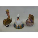 A Royal Crown Derby pelican, gold stopper, a cockerel and a swan, both silver stoppers.