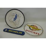Two Michelin cast metal signs and a third advertising Ducati.