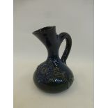 A late 19th Century pottery jug by Sir Edmund Elton, ovoid with oval spout, decorated with relief