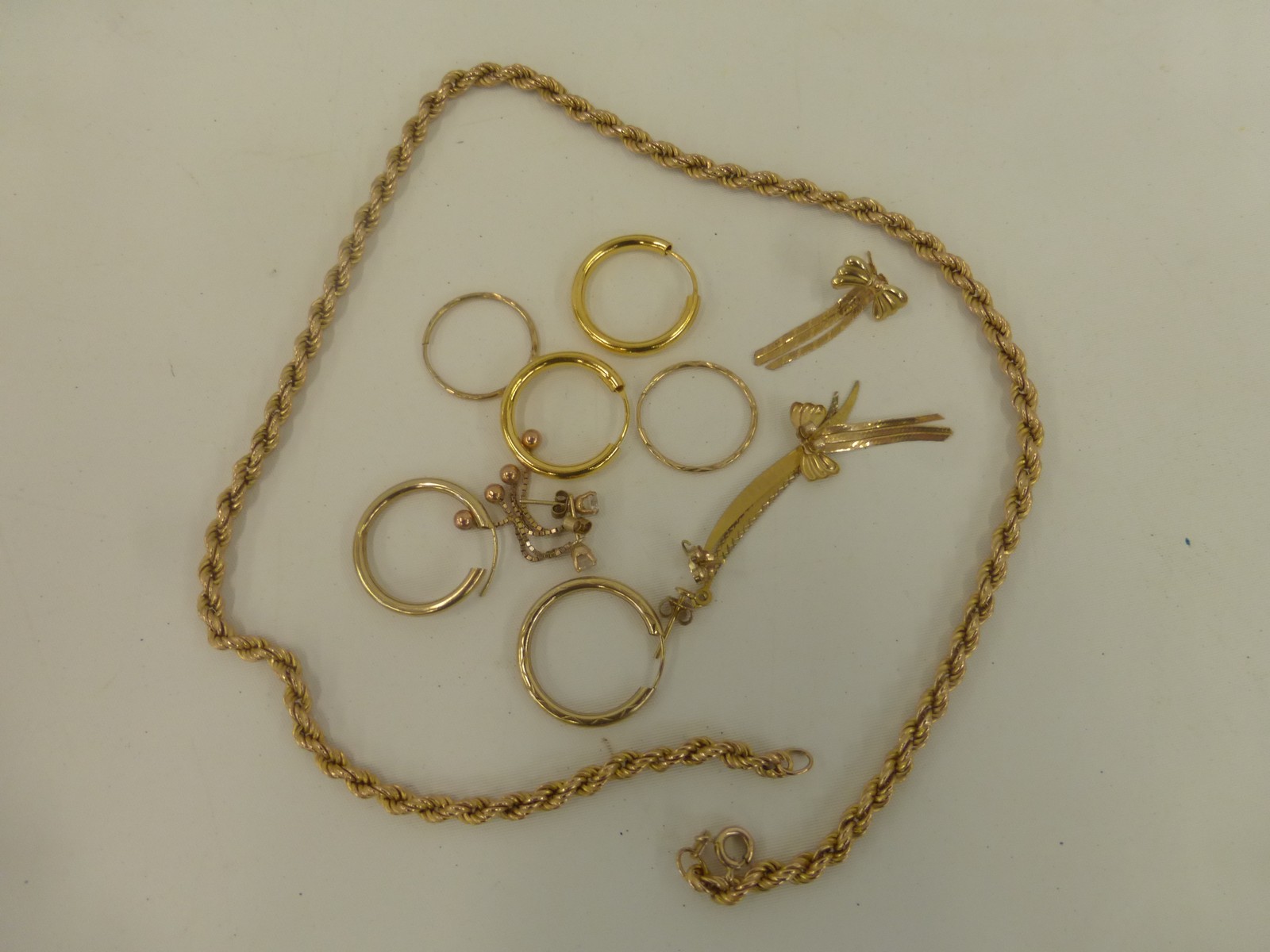 An assortment of 9ct gold jewellery including earrings and a sixteen inch gold necklace, weight 10.