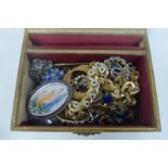 A box of assorted costume jewellery including brooches, an enamel bracelet etc.