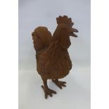 A cast metal weathered figure of a chicken.